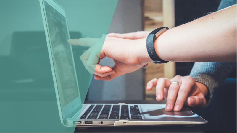Tech workers pointing at a laptop screen with their hands.