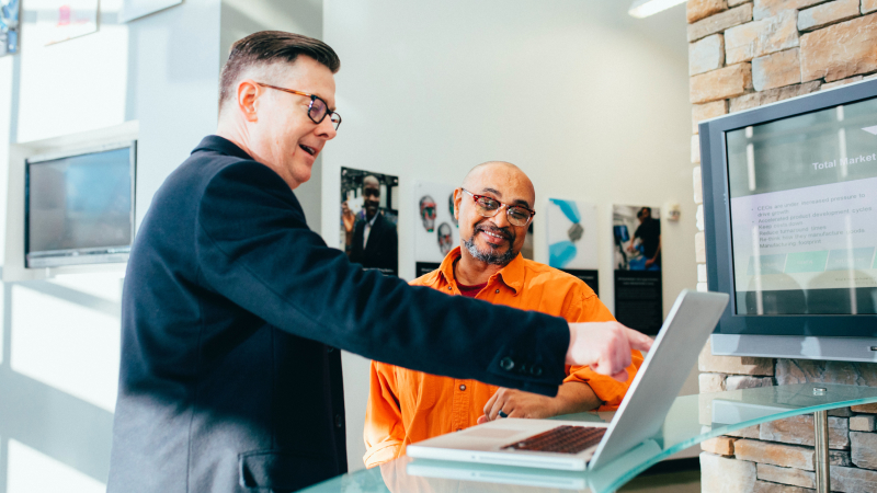 Business owner pointing at laptop screen on counter